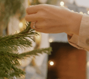 Hanging an ornament on a Christmas tree