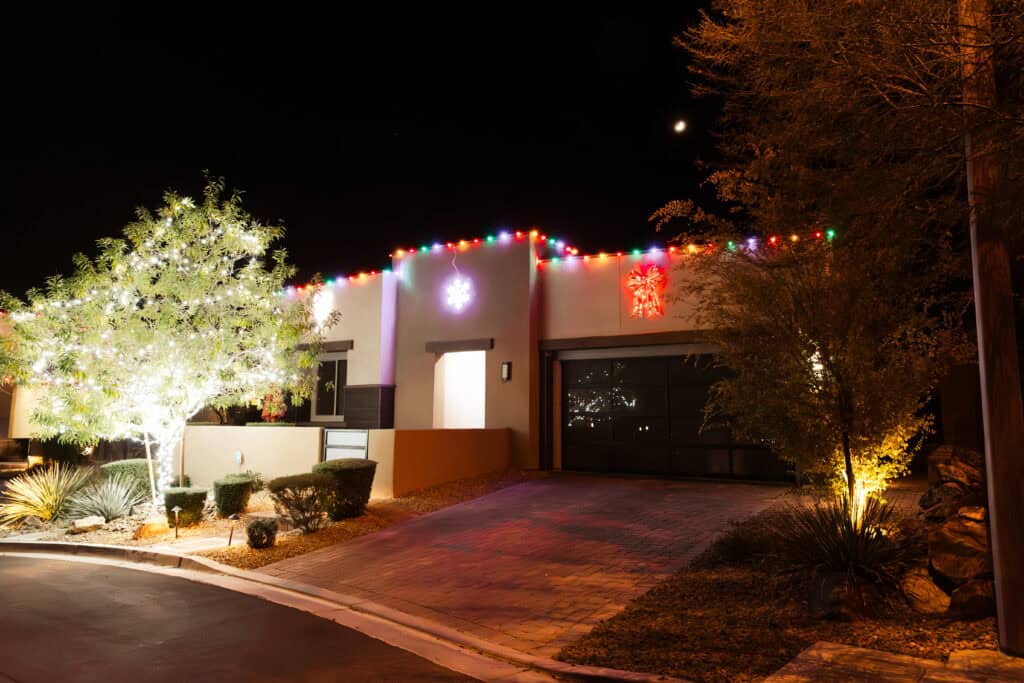 Multi-colored Christmas Lights Installed on tile roof, red Christmas bow light above garage, snowflake over front door
