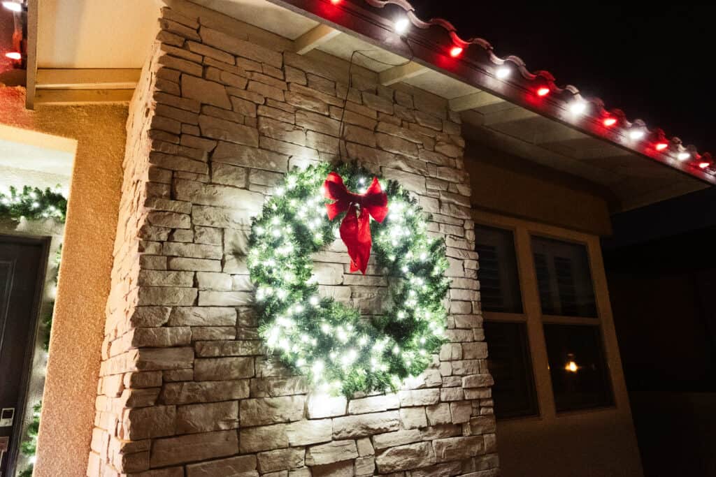 Pure White and Red Candy Cane Christmas Lights installed on a home in Austin Texas with a matching christmas wreath with pure white lights