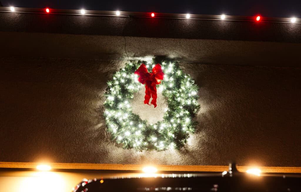 Pure White and Red Candy Cane Christmas Lights with a matching pure white lit christmas garland over the garage