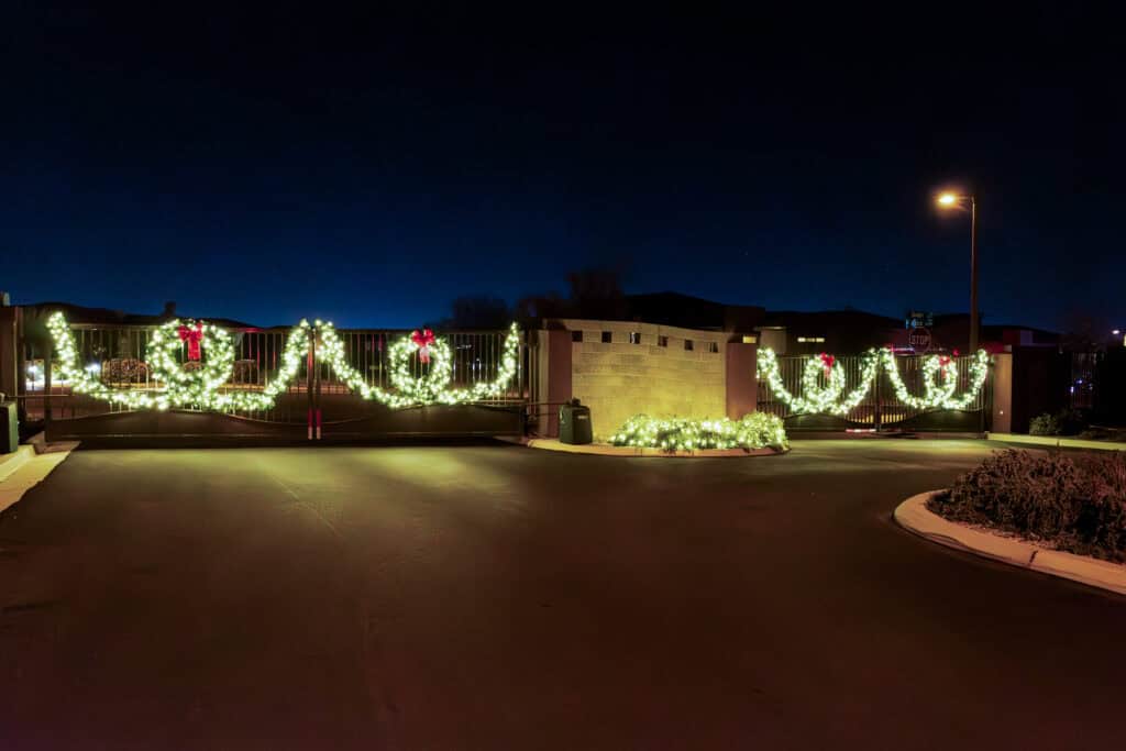 Warm white lighted garland and wreaths on a gated community entrance in Las Vegas