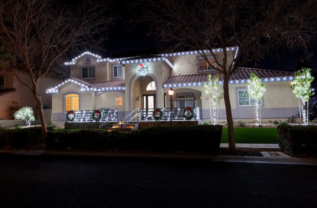Roof, dormer, and roofline outlined in bright white LED lights and matching lit wreaths for complete holiday decoration with turnkey ease and simplicity. Top christmas light installers near me